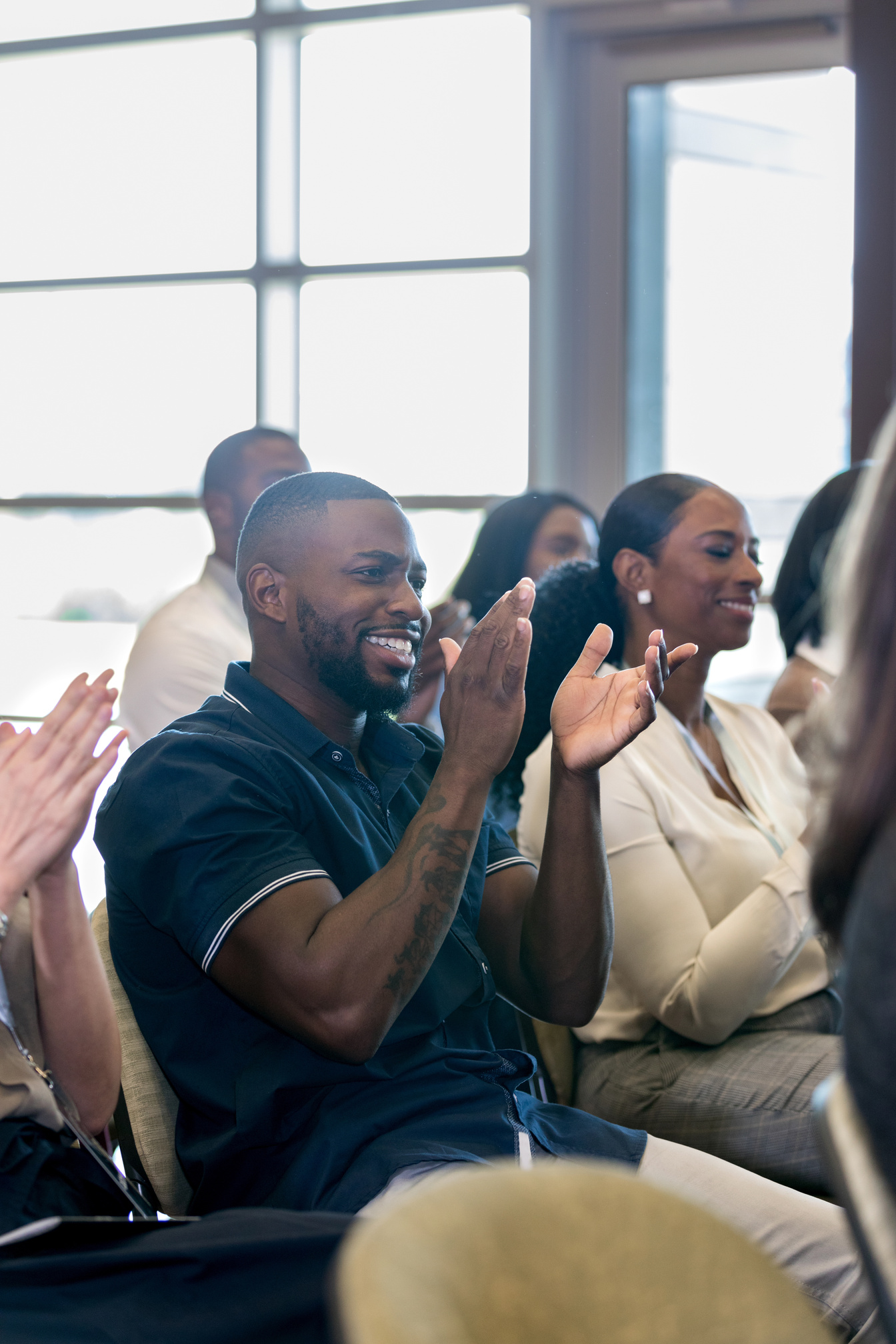 Happy African American man applauds conference speaker